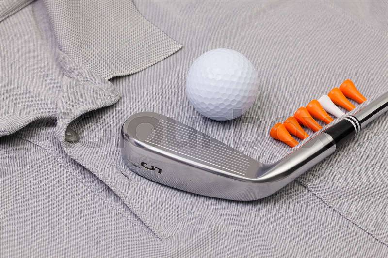 Detail of grey polo shirt and golf equipments, stock photo