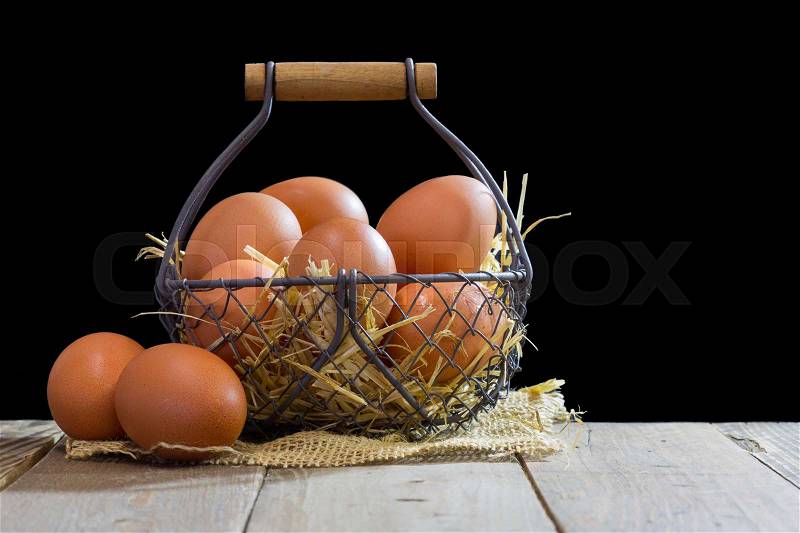 Wire basket with eggs and black background, stock photo
