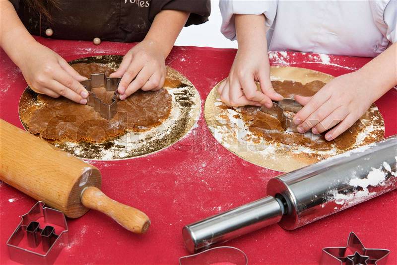 Children hands making gingerbread cookies with baking forms, stock photo