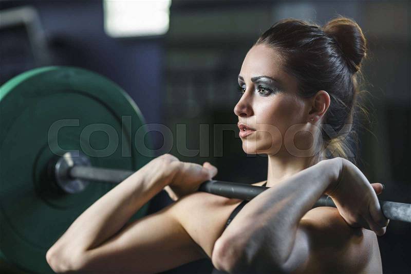 Concept: power, strength, healthy lifestyle, sport. Powerful attractive muscular woman CrossFit trainer do workout with barbell at the gym, stock photo