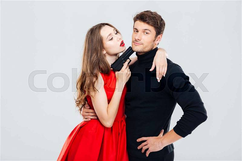 Sensual young couple playing and posing with gun, stock photo