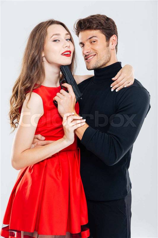 Happy stylish young couple posing with gun, stock photo