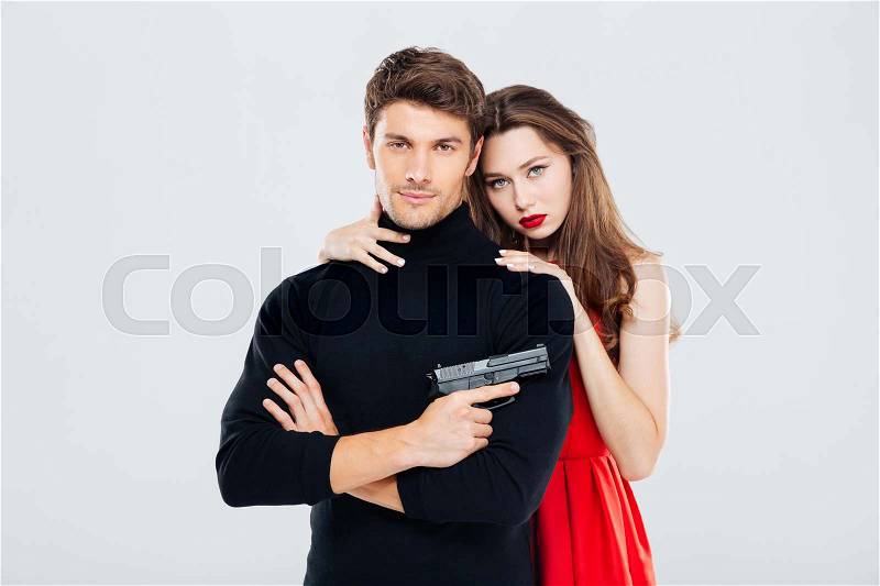 Portrait of beautiful stylish young couple with gun, stock photo