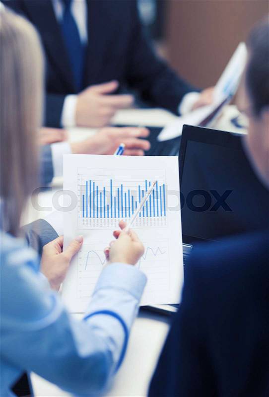 Business and office concept - close up of chats, laptop and graphs in office, stock photo