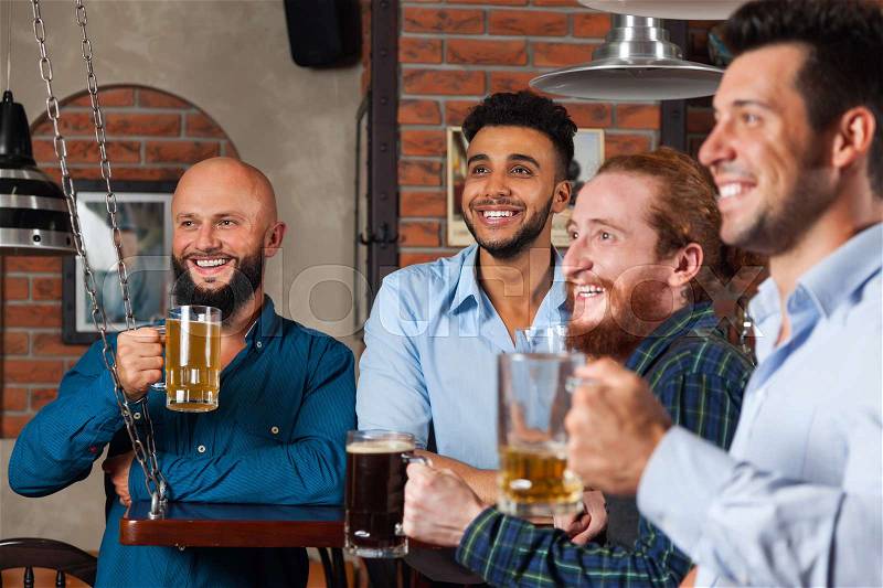 Man Group In Bar Happy Smiling And Watching Football, Drinking Beer Hold Mugs, Mix Race Cheerful Friends Wear Shirts Meeting Pub Communicate, stock photo