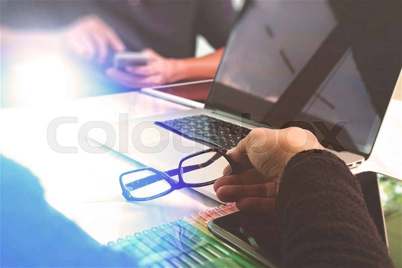 Two colleagues website designer discussing data and digital tablet and computer laptop with graphics design diagram on marble desk as concept, sun flare effect , stock photo