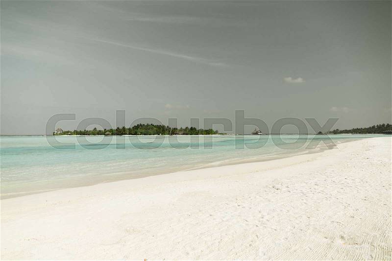 Travel, tourism, vacation and summer holidays concept - maldives island beach with palm tree and villa, stock photo