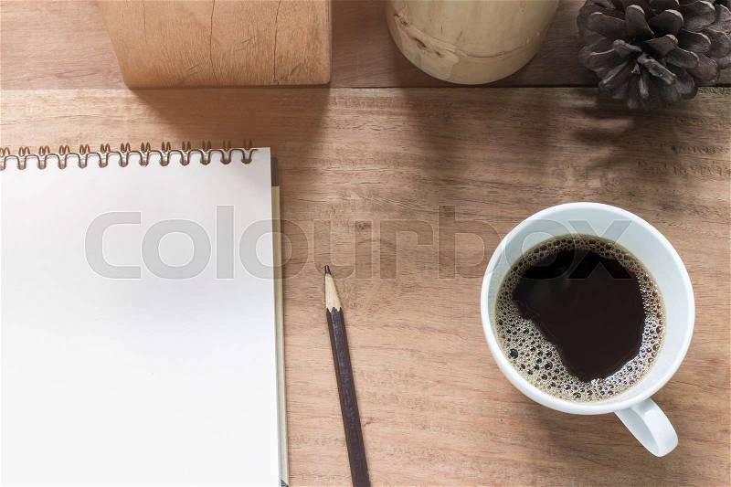 Black coffee cup and sketch on wooden desk, stock photo