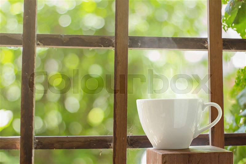 Hot coffee cup with smoke on wooden blurred background, stock photo