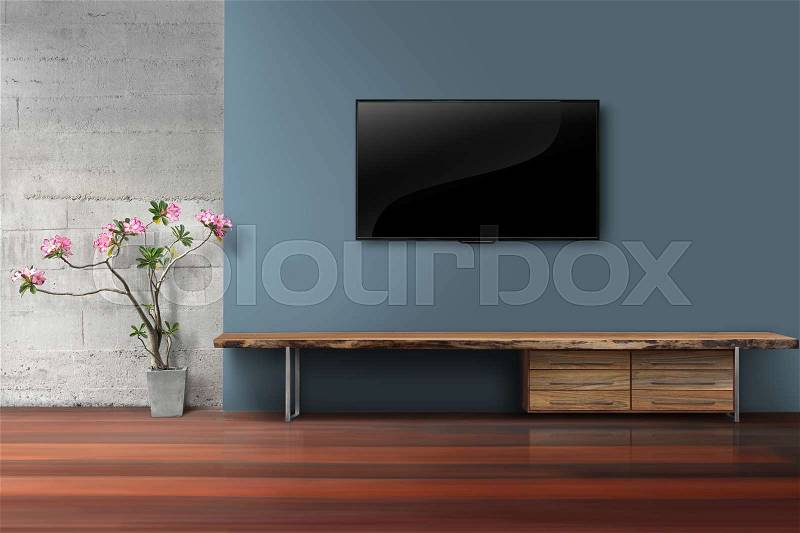 Living room led tv on blue color wall with empty wooden stand, stock photo
