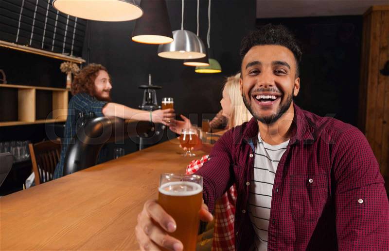 Young People Group In Bar, Hispanic Man Hold Glass Toasting Happy Smiling, Friends Sitting At Wooden Counter Pub, Communication Party Celebration, stock photo