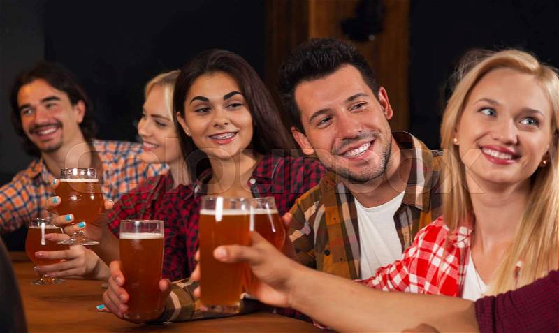 Young People Group In Bar, Hold Beer Glasses Speaking, Friends Sitting At Wooden Table Chatting Pub, Friends Happy Smiling Communication Party Celebration, stock photo