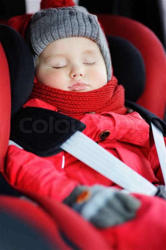 Portrait of toddler boy sleeping in car seat. Transportation safety, stock photo