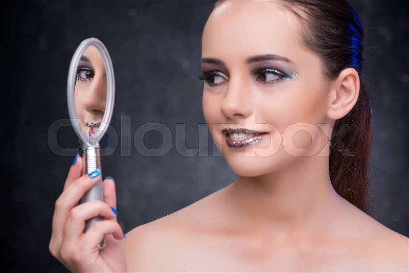 Young woman with small mirror in beauty concept, stock photo