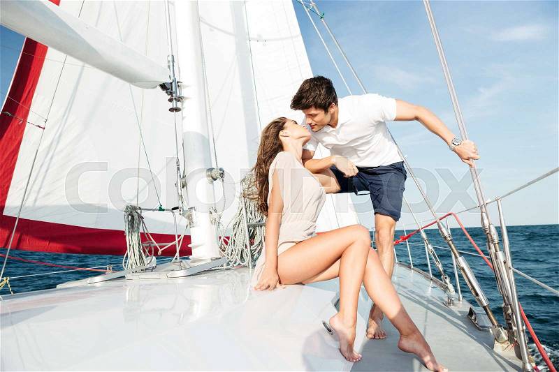 Young beautiful married couple kissing on the yacht on vacation, stock photo