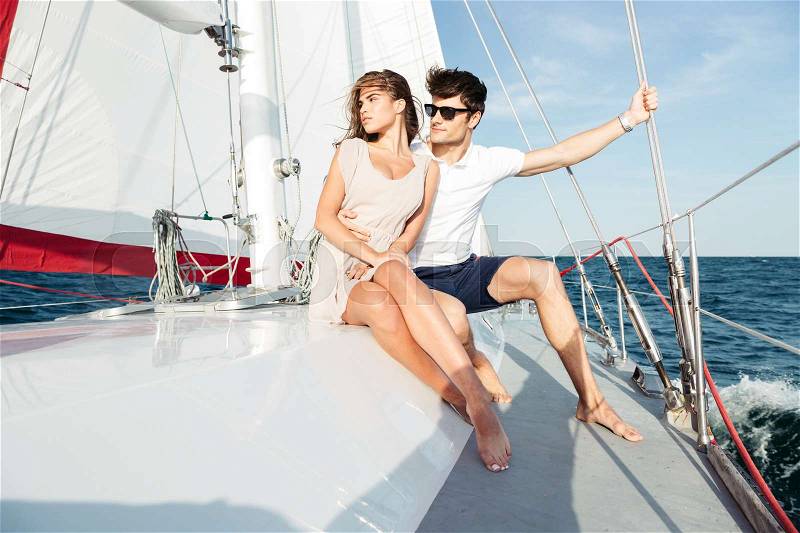 Young beautiful married couple embracing on the yacht on vacation, stock photo