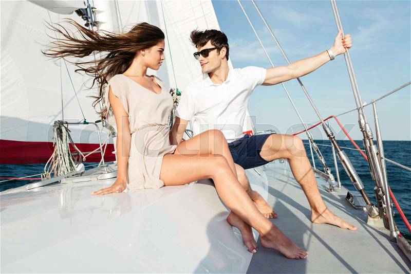 Young beautiful married couple embracing on the yacht on vacation, stock photo