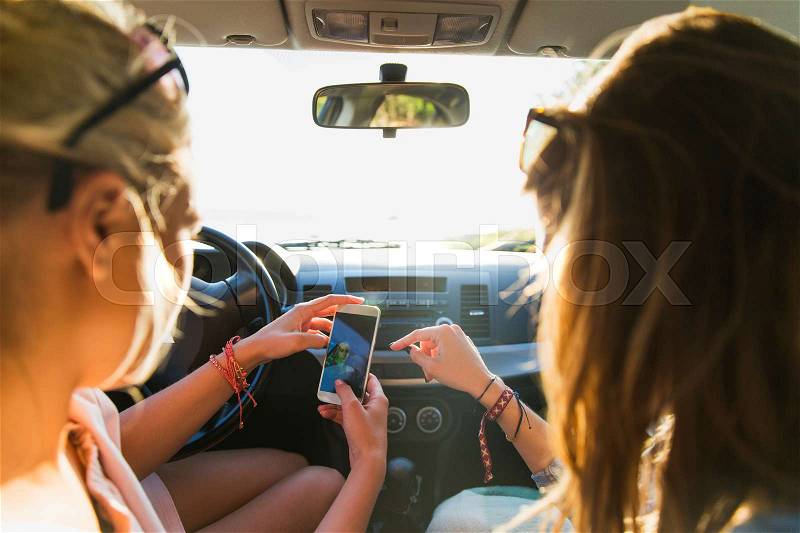 Summer vacation, holidays, travel, road trip and people concept - happy teenage girls or young women with smartphone taking selfie in car, stock photo