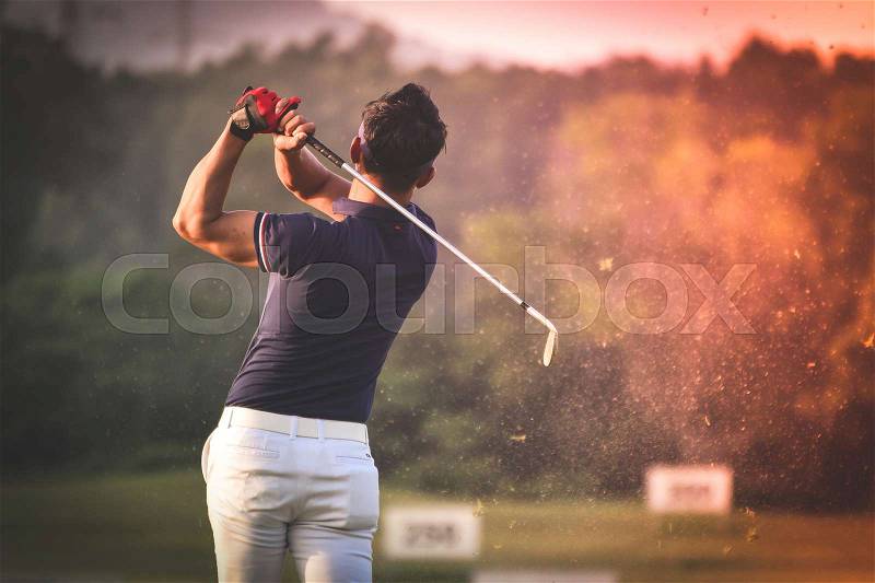 Golfer hitting golf shot with club on course vintage color tone, stock photo