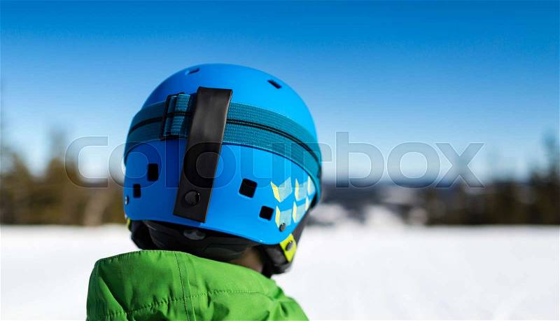 Close-up of young male skier standing on ski piste at ski resort on sunny winter day, stock photo
