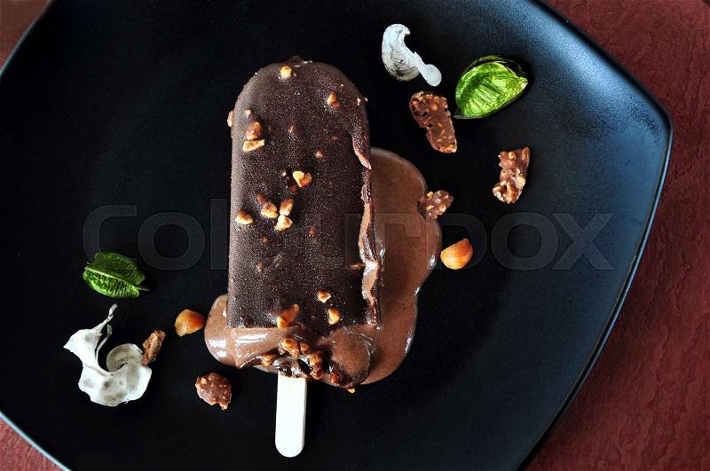 Top view of melting chocolate ice cream bar on black background, stock photo