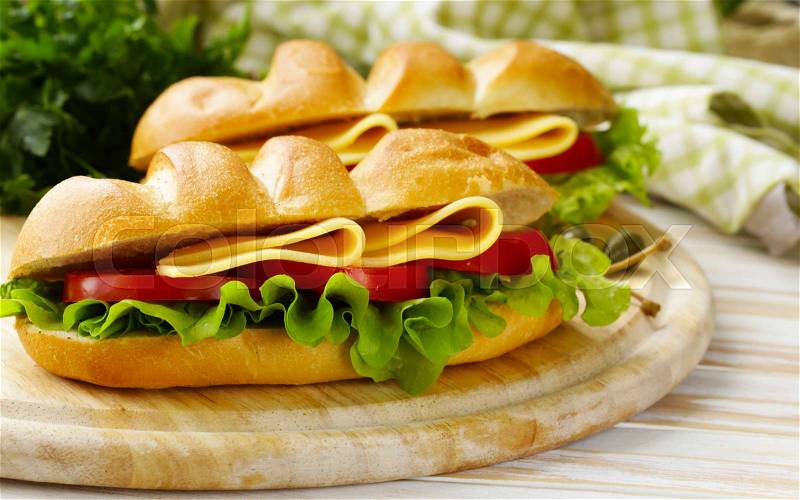 Baguette sandwich with vegetables, cheese and ham, stock photo