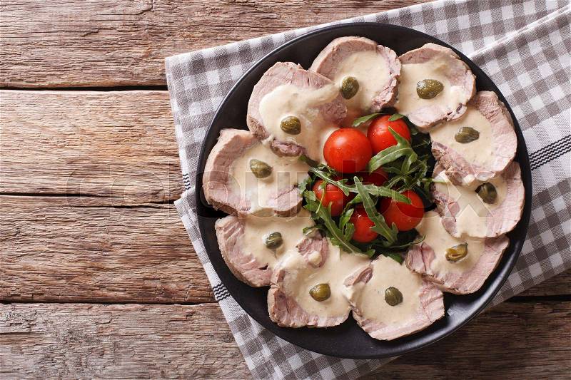 Italian cuisine: Vitello tonnato with capers, arugula, tomatoes on a plate close-up. horizontal view from above , stock photo