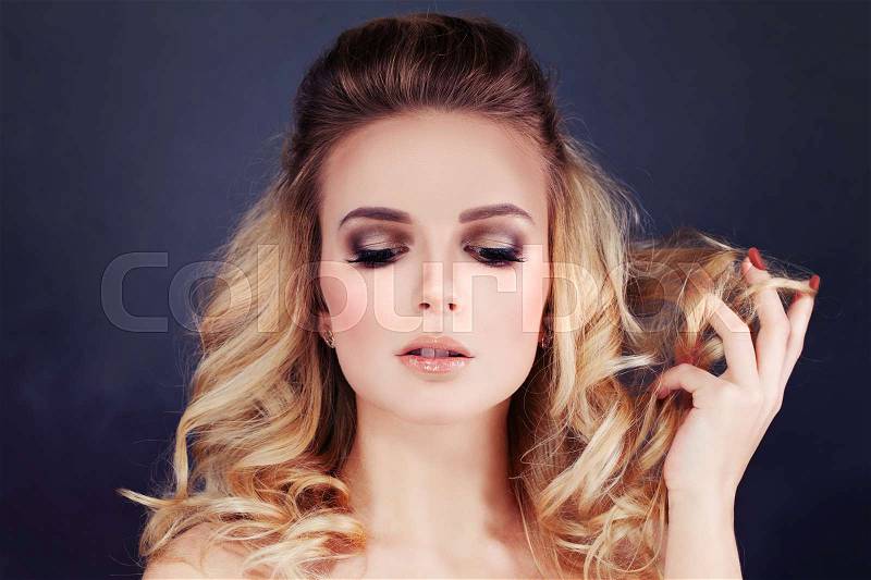 Beautiful Woman with Blonde Hair. Curly Hairstyle and Make-up, stock photo
