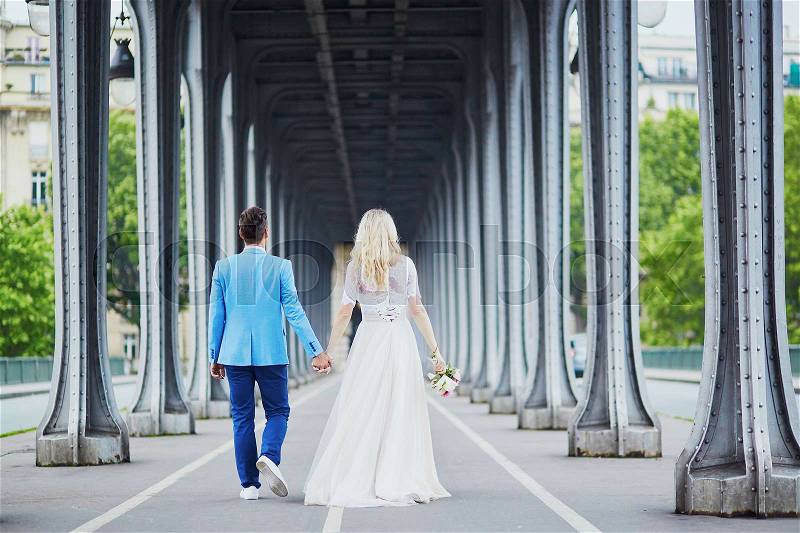 Just married couple in Paris, France. Beautiful young bride and groom on Bir-Hakeim bridge. Romantic wedding concept, stock photo