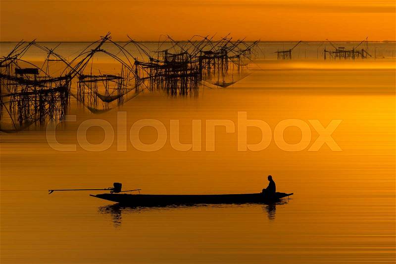 Silhouette of fishermen boat and fish trap machine in songkhla lake , Phatthalung , Thailand, stock photo