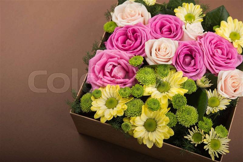 Gift box with flowers on vintage brown background, stock photo