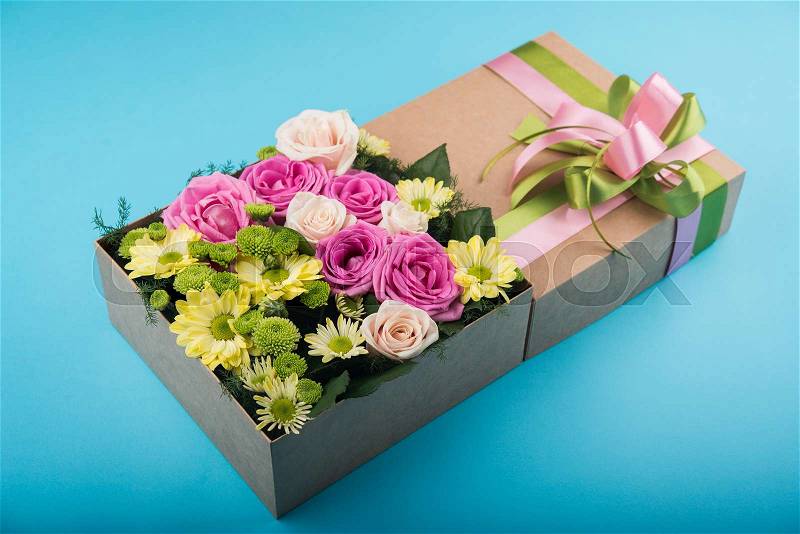 Beautiful gift box with flowers. wedding decoration accessory. blue background, stock photo