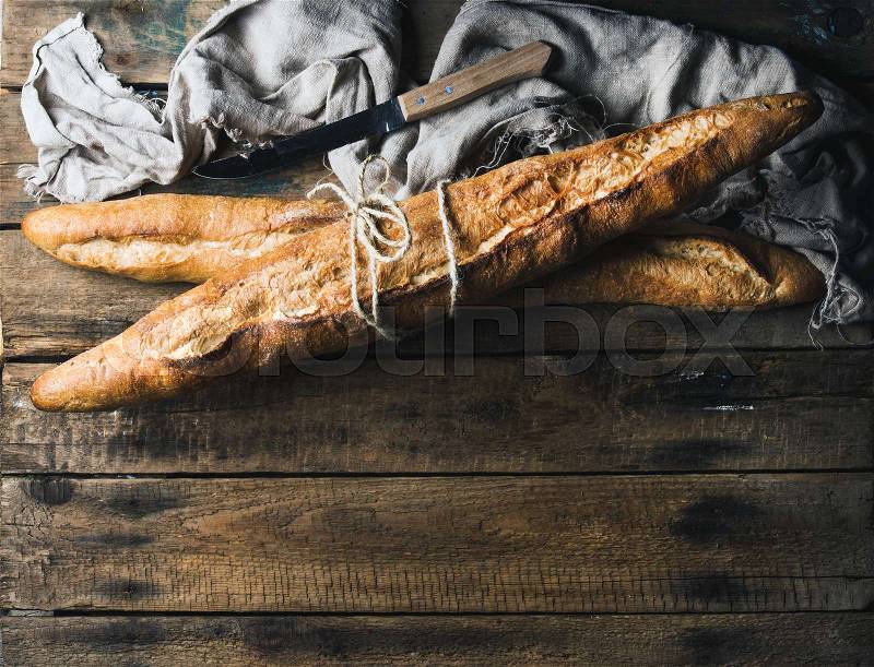 French baguettes on rough rustic wooden background. Top view, copy space, stock photo