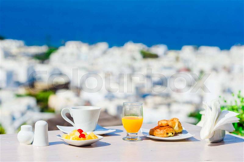 Breakfast served table by the sea. Perfect luxury breakfast table outdoors. Amazing caldera view on Mykonos, Greece, Europe, stock photo