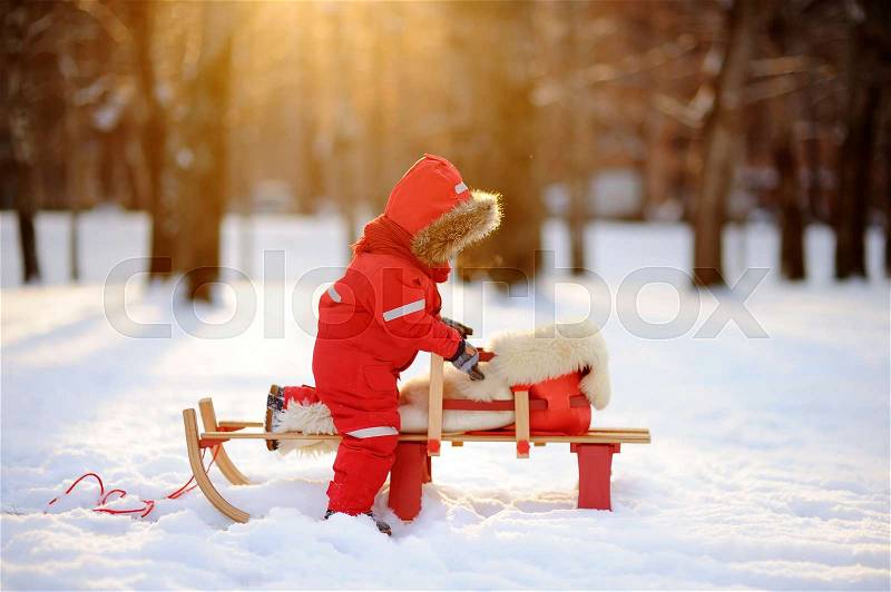 Toddler boy having fun in winter park. Game with fresh snow, stock photo