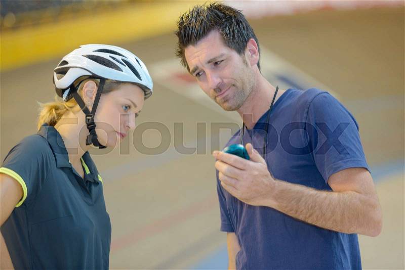 Coach expressing disappointment at cyclists time, stock photo