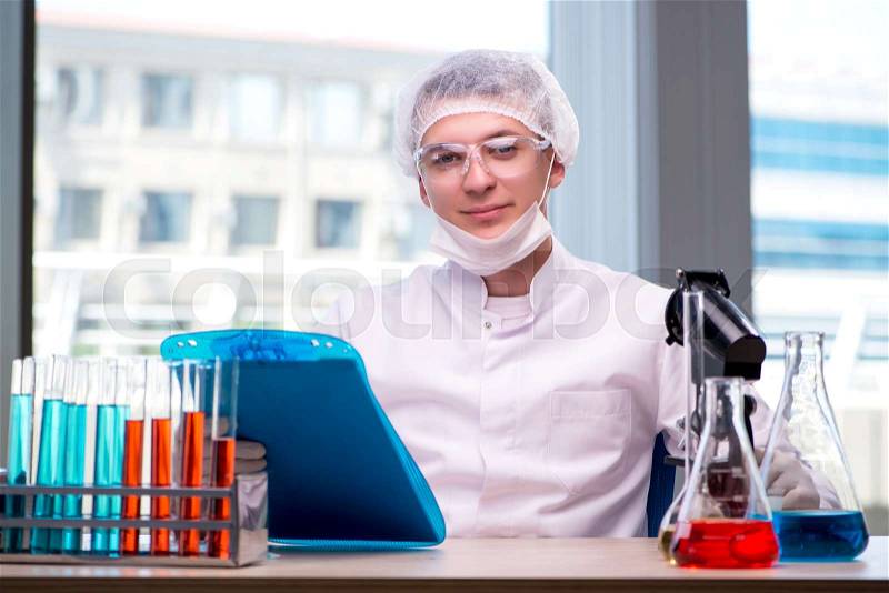 Young chemist working in the lab, stock photo
