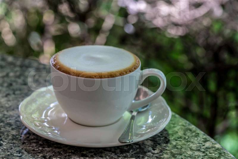 White Cup of cappuccino coffee on gray granite desk, stock photo