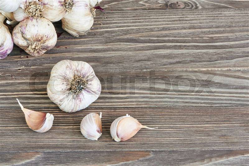 Garlic bulbs and cloves on wooden background, stock photo