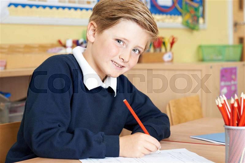 Male Elementary School Pupil Working At Desk, stock photo