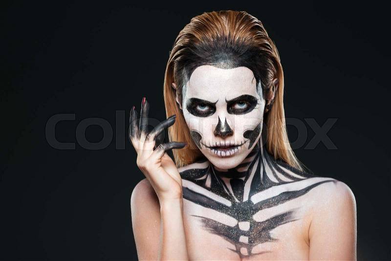 Portrait of young woman with scared halloween makeup over black background, stock photo