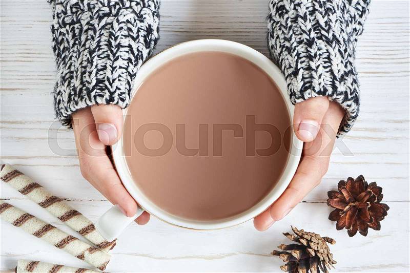 Cocoa cup and woman hand on wooden background, stock photo