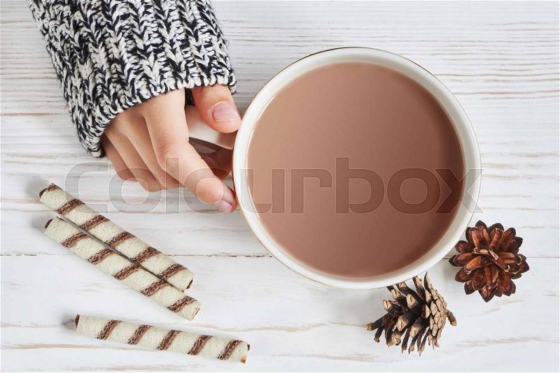 Cocoa cup and woman hand on wooden background, stock photo