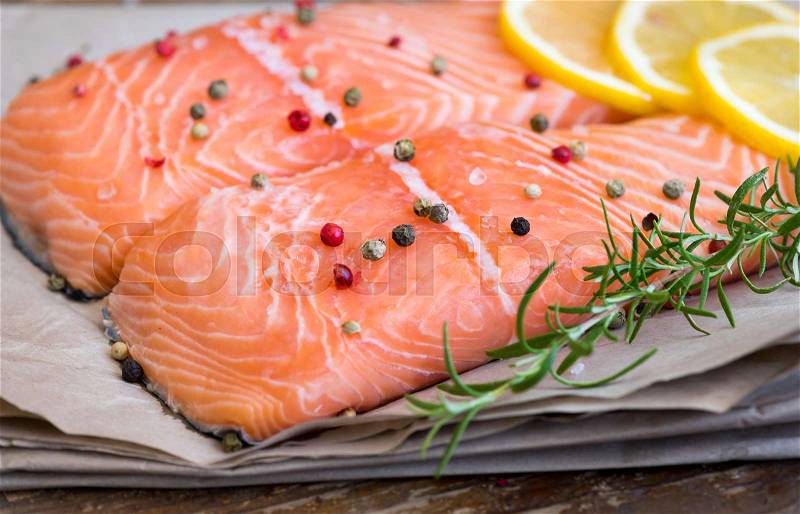 Detail of Raw Salmon Fish Fillet with Lemon, Spices and Fresh Herbs Ready for Cooking, stock photo