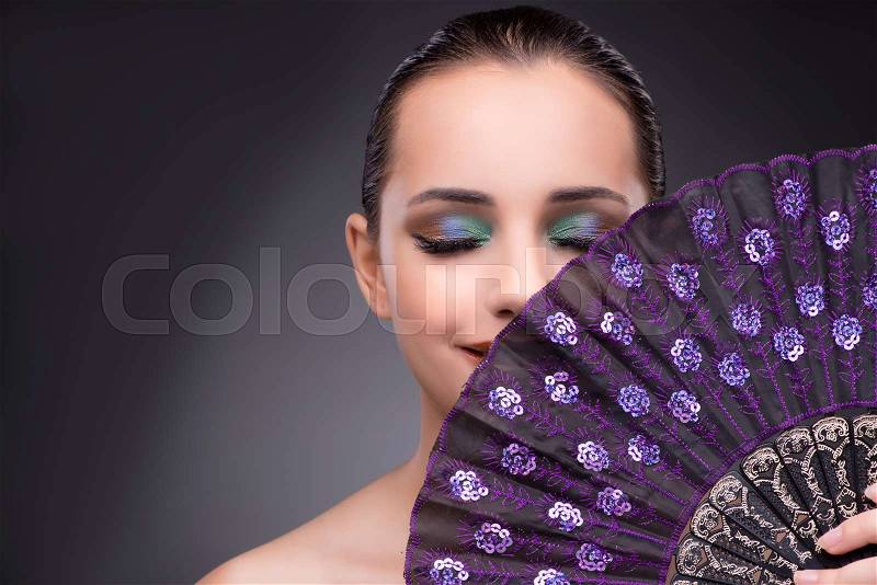 Beautiful woman with fan in fashion concept, stock photo