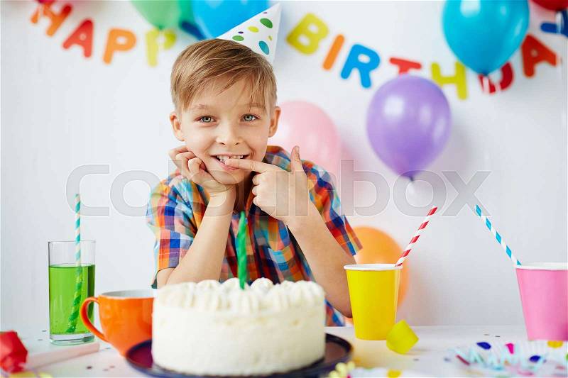 Cute boy tasting yummy birthday dessert, stock photo