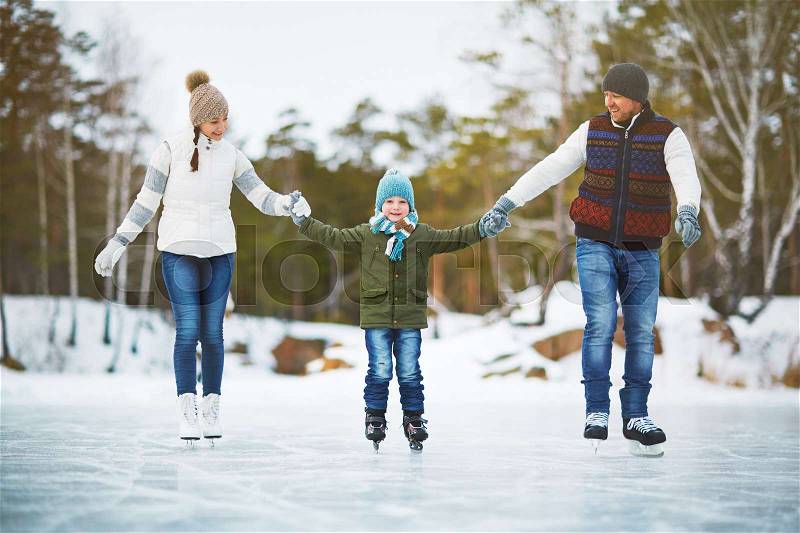 Sportive family skating on ice-rink, stock photo