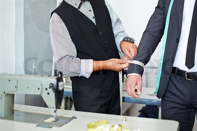 Tailor measuring girth of jacket sleeve, stock photo