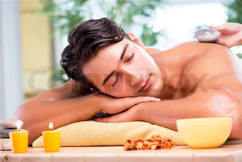 Young handsome man during spa procedure, stock photo