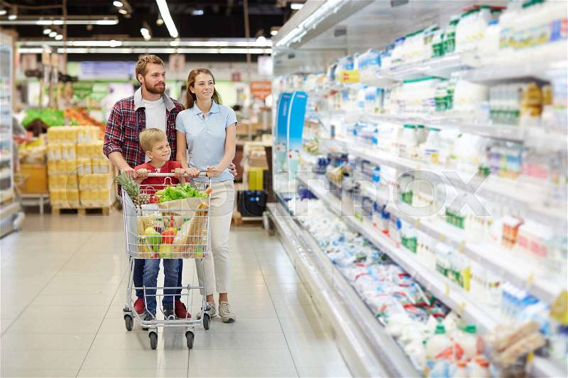 Young couple and their son buying products in supermarket, stock photo